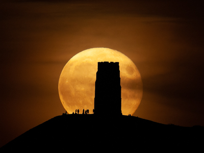 Picture of moon rising behind Glastonbury Tor