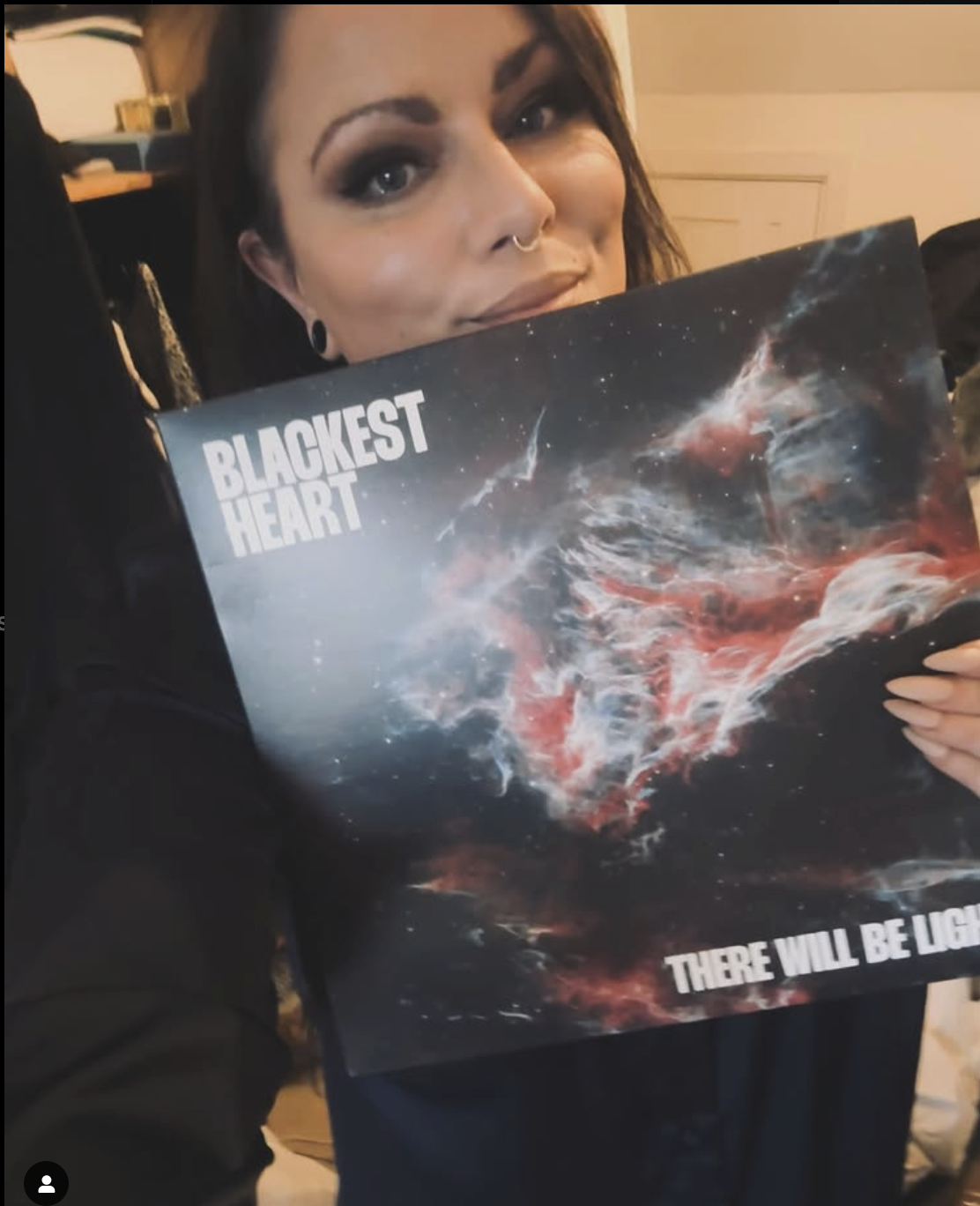 A photo of Hannah Rochford holding an album cover featuring one of her photographs